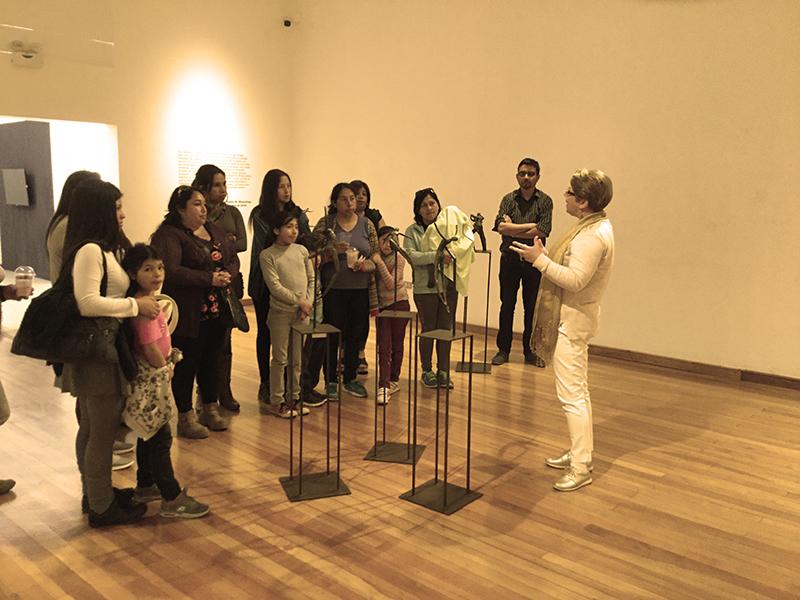 Un grupo de personas escuchan a la escultora Tatiana Martin