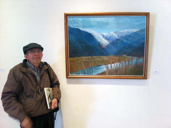 El artista Franklin Gahona junto a su obra "Valle Místico" perteneciente a la Pinacoteca de la Universidad Católica del Norte.