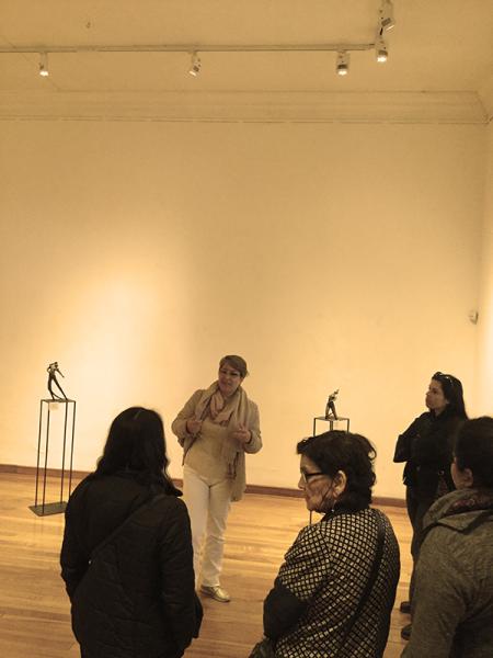 Tatiana Martin mostrando sus obras a un grupo de mujeres