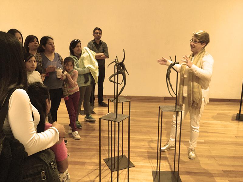 Tatiana Martin mostrando sus obras a un grupo de visitantes